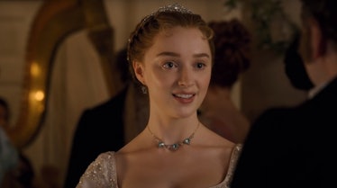 Daphne Bridgerton is all dressed up and talks to someone at a lavish ball in 'Bridgerton.'