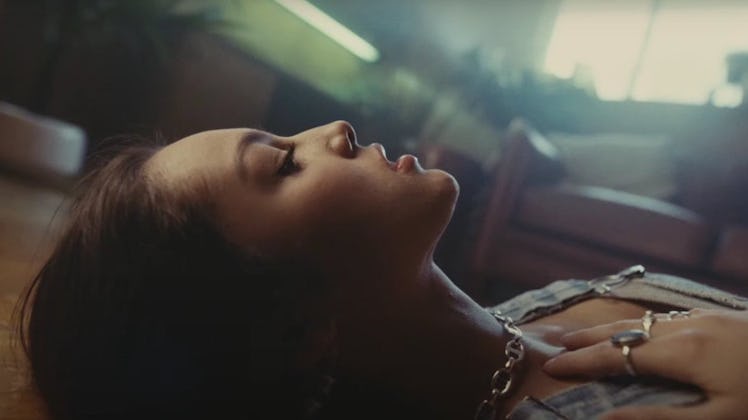 Olivia Rodrigo lays in her bedroom floor while wearing a necklace and rings in her "Drivers License"...