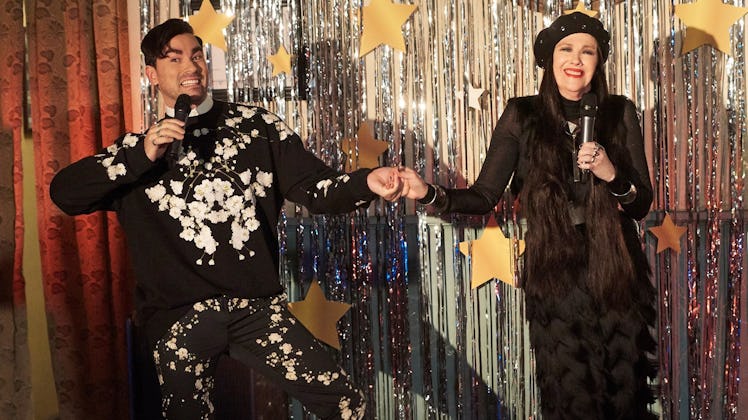 David and Moira Rose sing in front of a silver foil curtain on 'Schitt's Creek.'