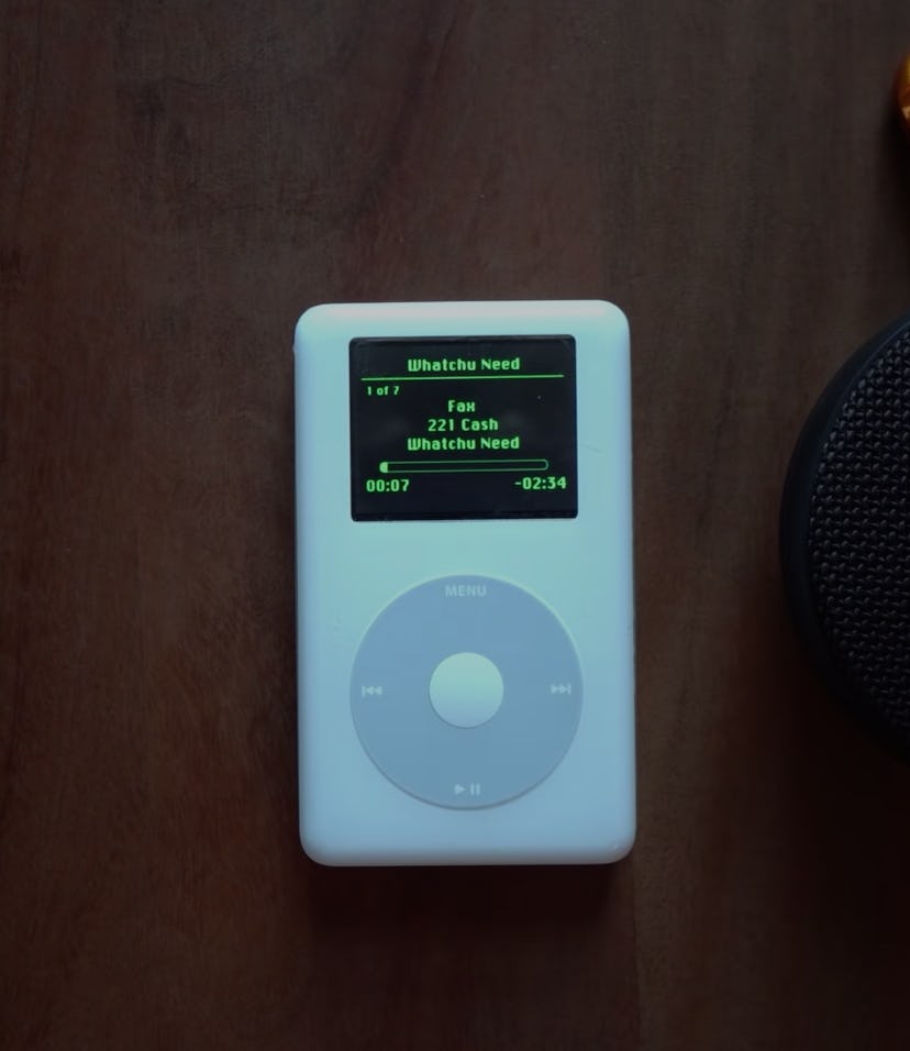 A screenshot of a 17-year-old iPod with Spotify streaming on it. It is placed next to a bluetooth sp...
