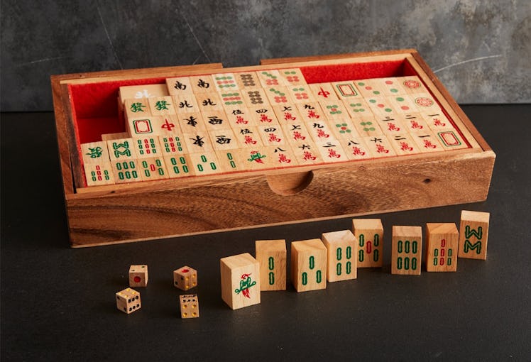 A traditional wooden mahjong set is displayed in a handcrafted wooden box.