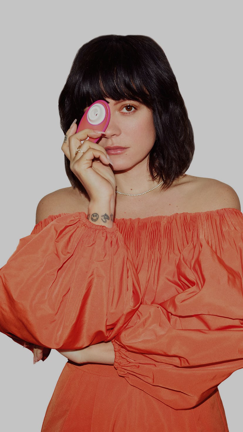 Singer Lily Allen poses with a Womanizer Liberty suction stimulator toy, holding it in front of her ...