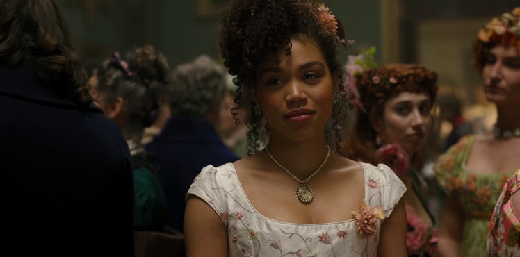 Marina from 'Bridgerton' smiles at a ball while wearing a beautiful white and pink gown.