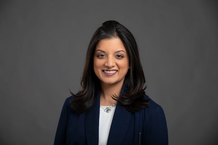 Dr. Shikha Jain in a blue blazer and white shirt smiling and posing for a portrait