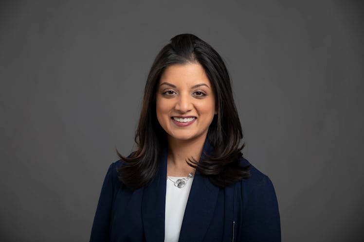 Dr. Shikha Jain in a blue blazer and white shirt smiling and posing for a portrait