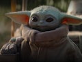 Baby Yoda stares off into the distance in his cozy robe.