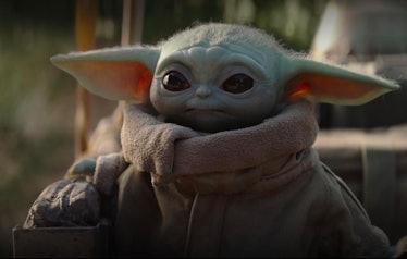 Baby Yoda stares off into the distance in his cozy robe.