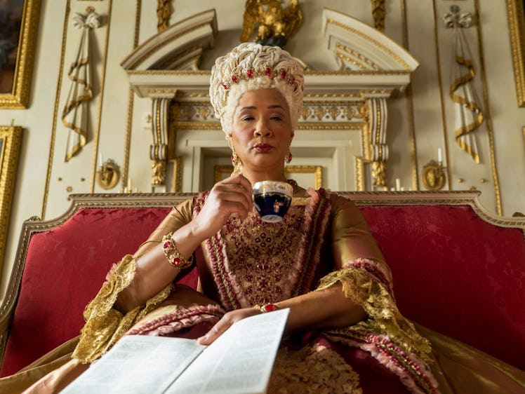 The Queen in 'Bridgerton' sips her tea while holding Lady Whistledown's paper.