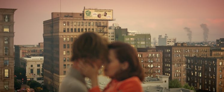 A young couple kiss on a rooftop in the city at sunset during Justin Bieber's "Anyone" music video.