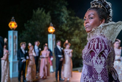 Adjoa Andoh as Lady Danbury on Bridgerton looks in the distance wearing an ornate purple gown and ti...