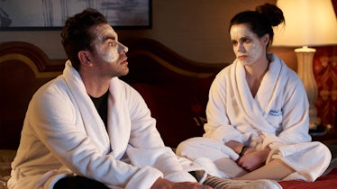 Stevie Budd and David Rose sit in bed wearing matching face masks and robe for a BFF night.