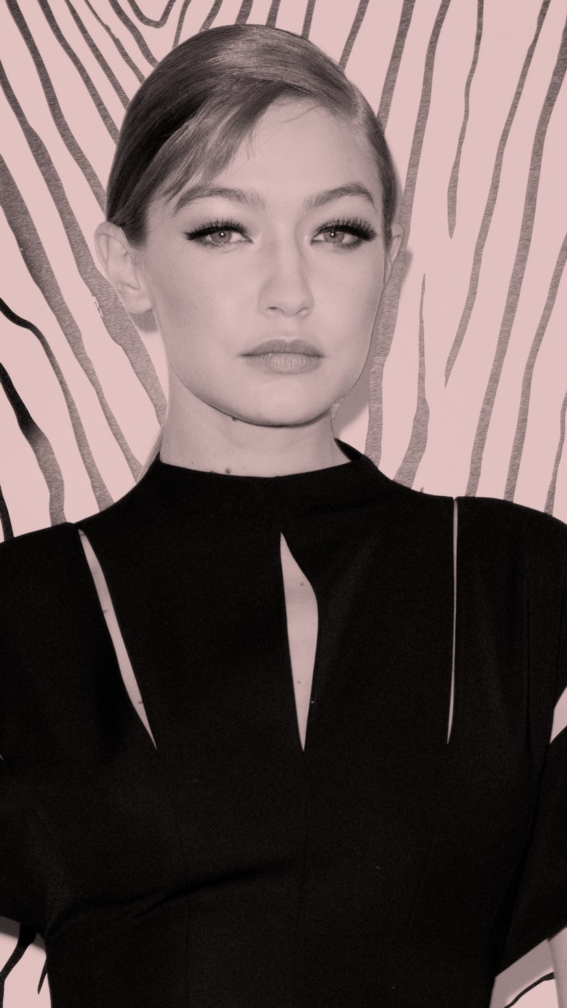 Gigi Hadid poses in a black dress, her hair pulled back in a tight bun.