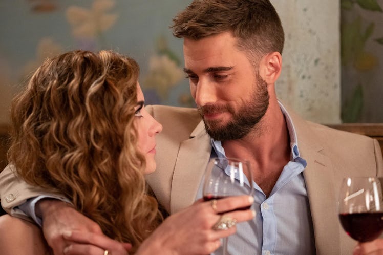 Alexis and Ted from "Schitt's Creek' hold wine glasses while looking into each other's eyes at a caf...
