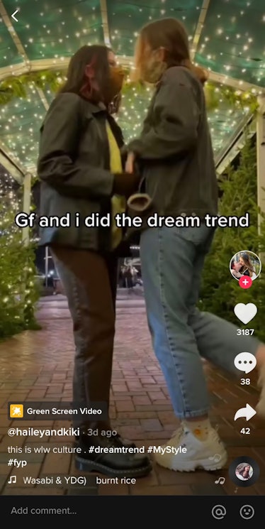A couple stands under a lit greenery arch while wearing masks, in a dream trend video on TikTok.
