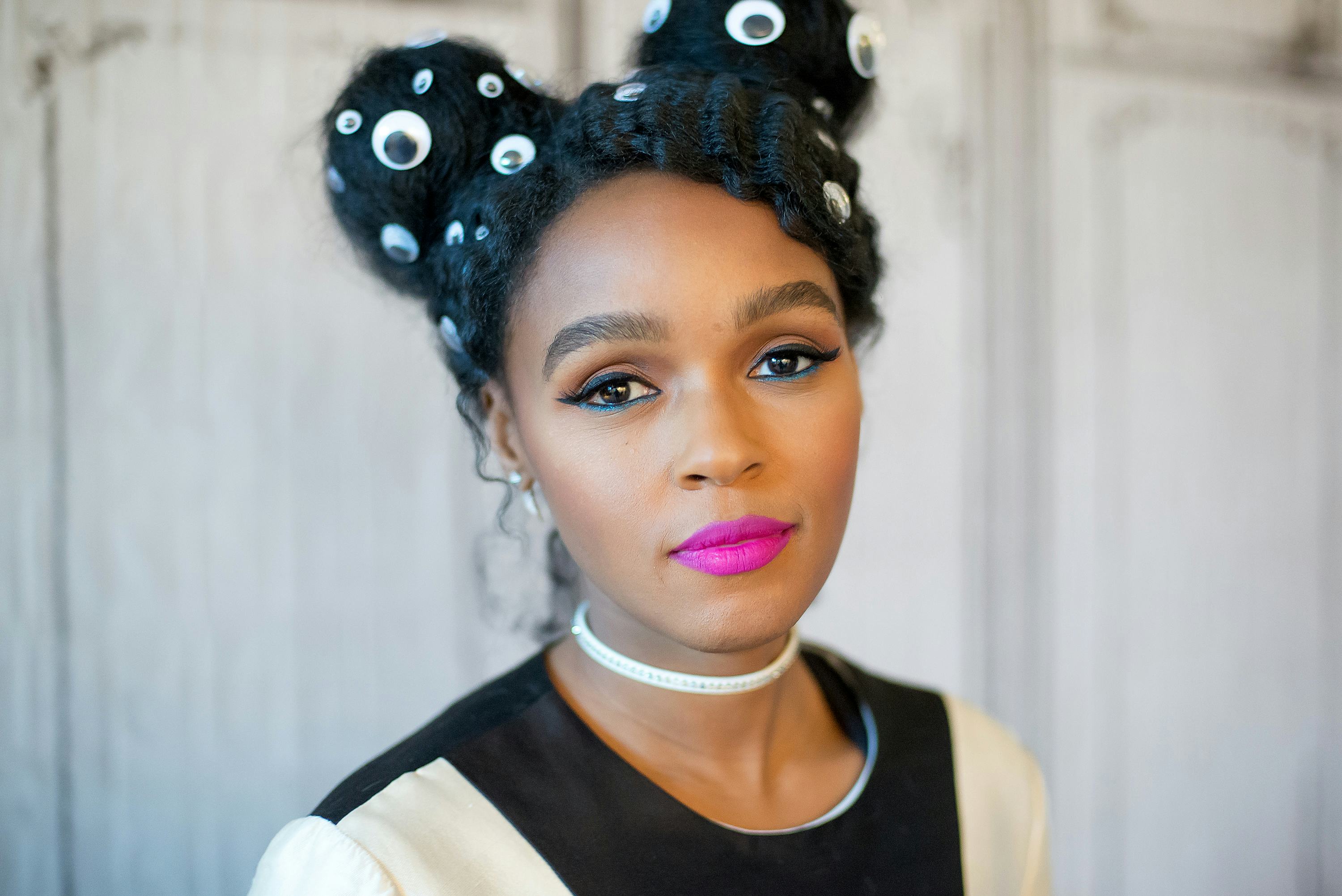 Janelle Monae, wearing her hair in two braided space buns that featured eye stickers, smiles at the ...