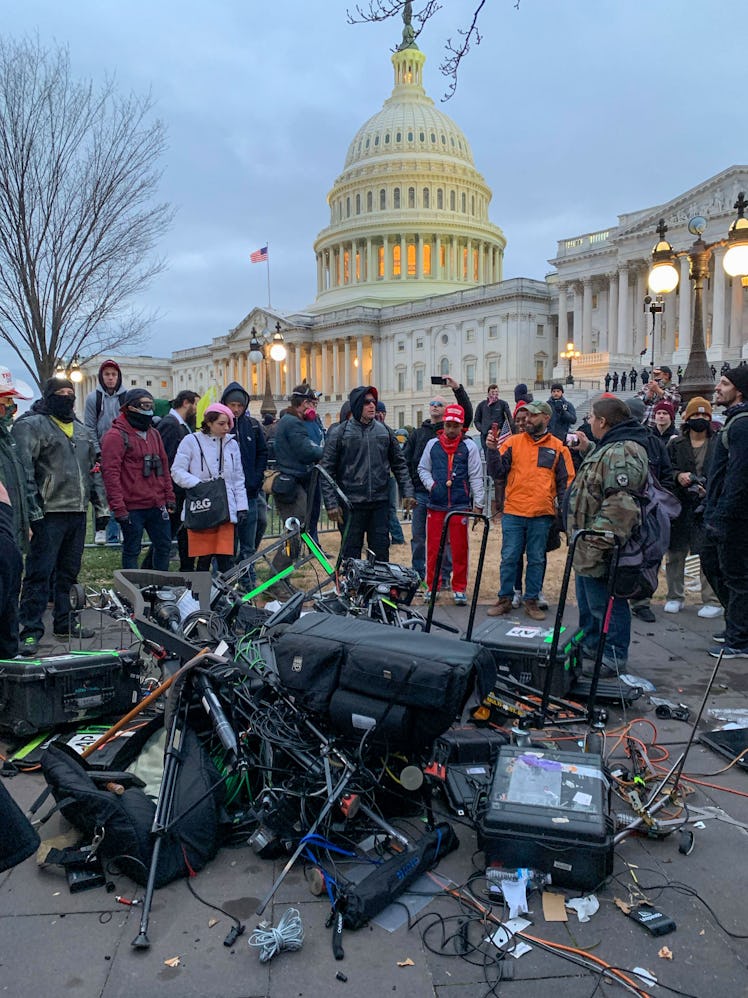 People stand around media equipment destroyed by Trump supporters outside the US Capitol in Washingt...