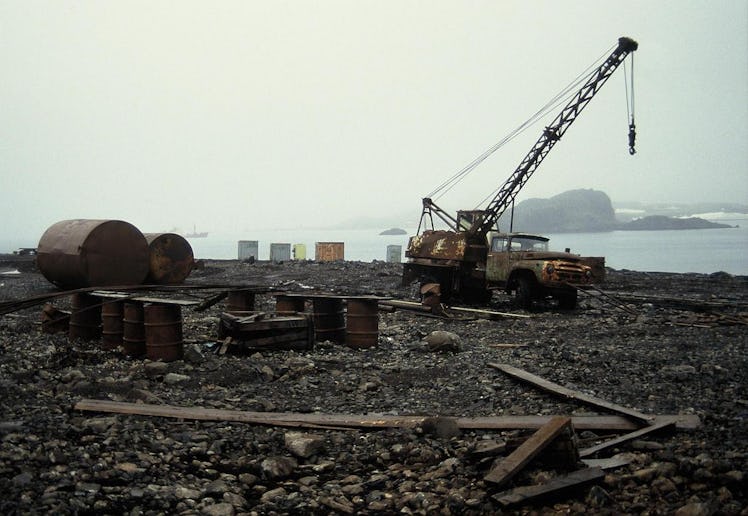 An old ZIL-130 truck, rusting drums, and other refuse litter the shoreline at Bellingshausen, a Russ...