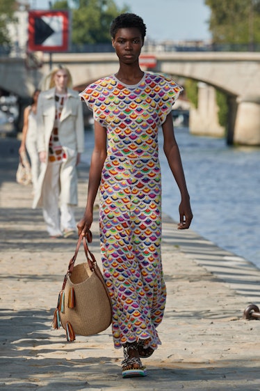 Model walking in a multi-colored dress at the Chloé fashion show at Paris Fashion Week Spring 2022