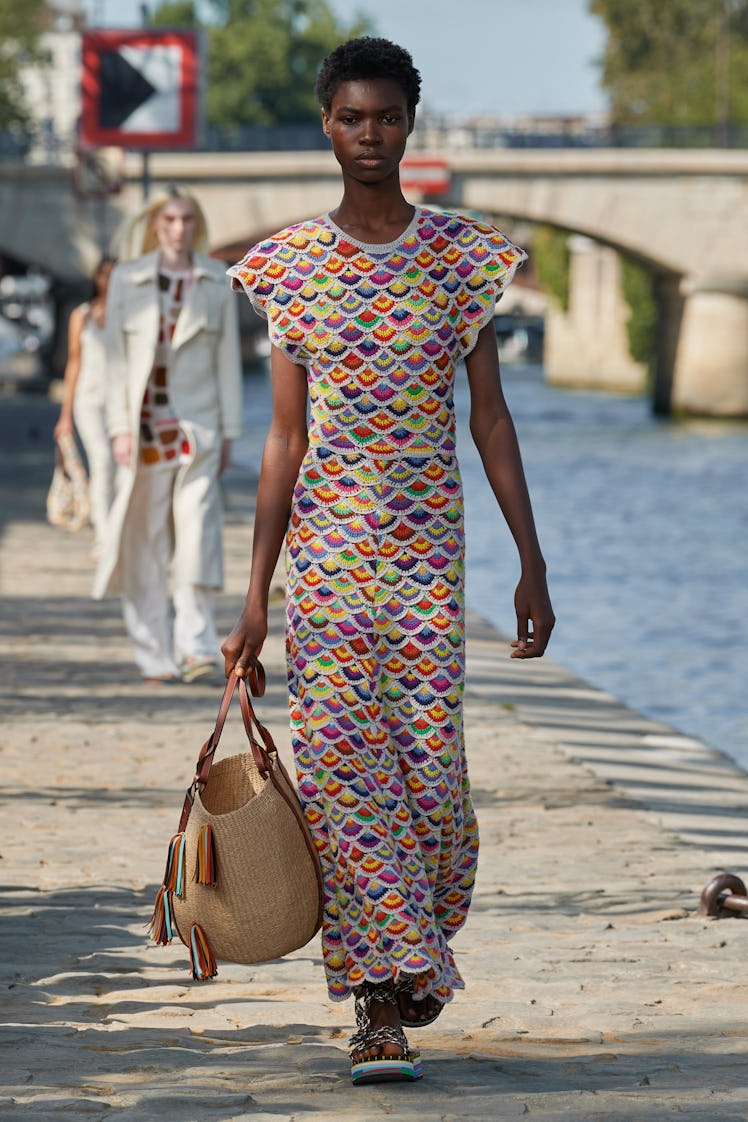 Model walking in a multi-colored dress at the Chloé fashion show at Paris Fashion Week Spring 2022
