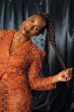 Issa Rae in an orange dress posing for The Good Ones Issue: The Voices that Made an Impact