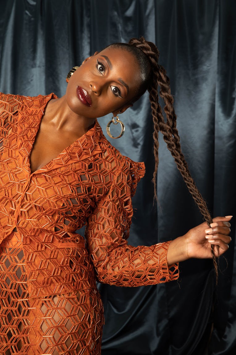 Issa Rae in an orange dress posing for The Good Ones Issue: The Voices that Made an Impact