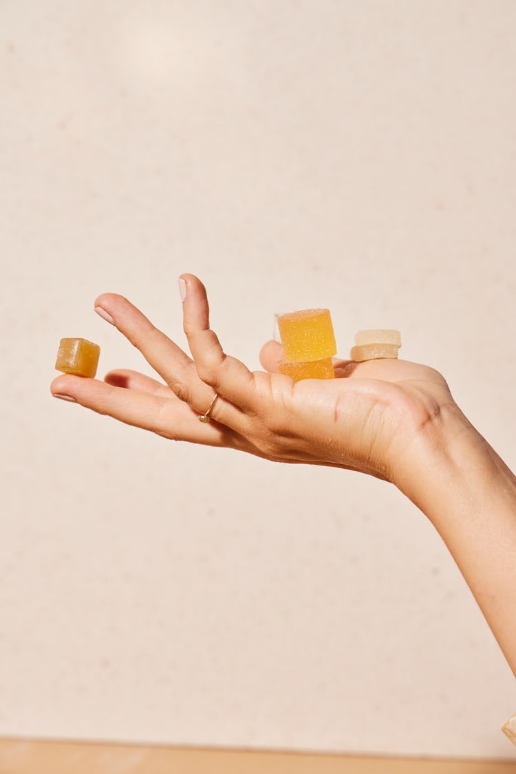 hand holding gummies, artfully arranged in front of a white background