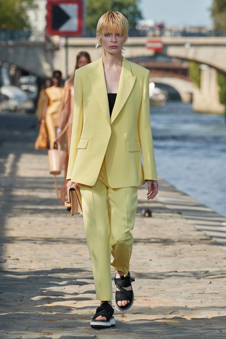 Model walking in a yellow suit at the Chloé fashion show at Paris Fashion Week Spring 2022