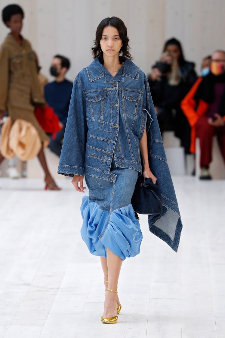 A model walking in a denim jacket-dress at the Loewe spring 2022 show at Paris Fashion Week.