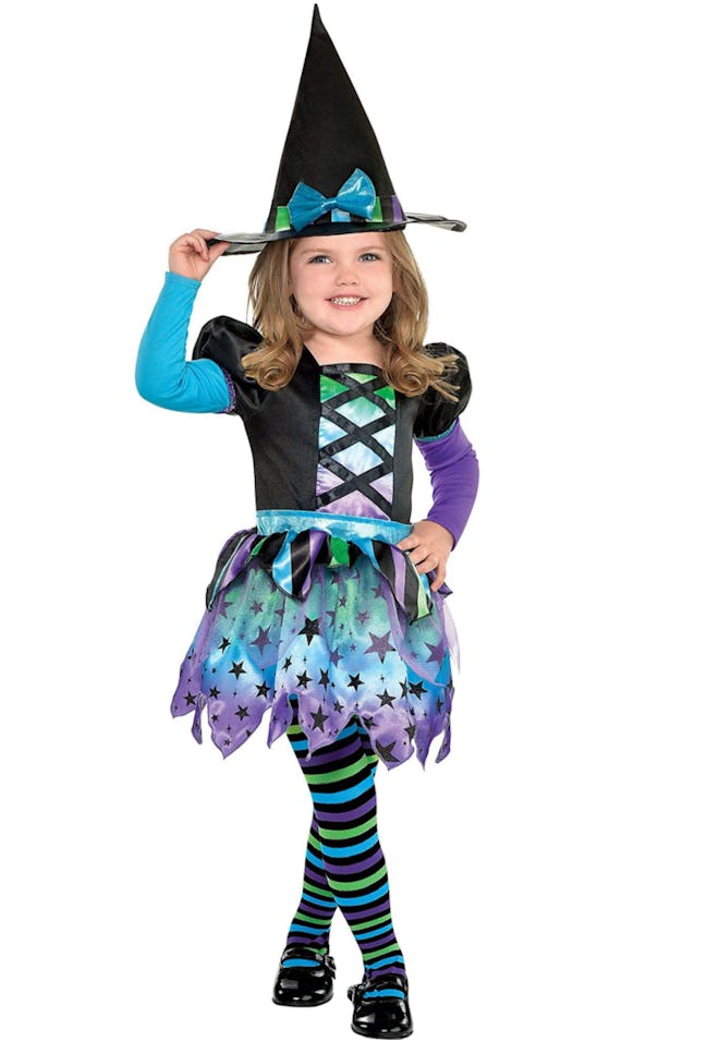 Toddler girl posing in witch costume