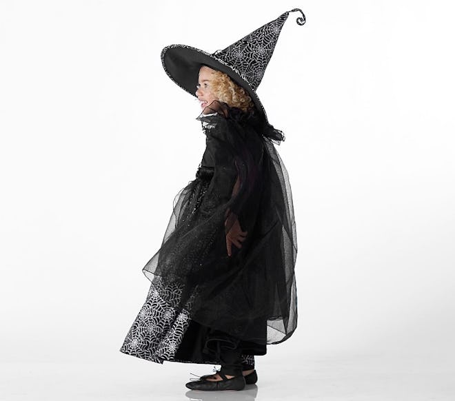 Toddler girl posing in witch costume