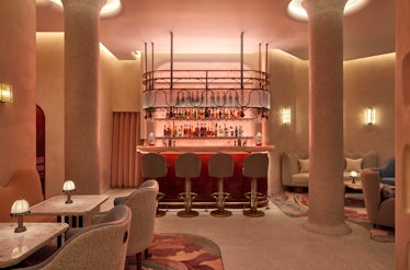 a dimly lit, elegant bar flanked by two white columns