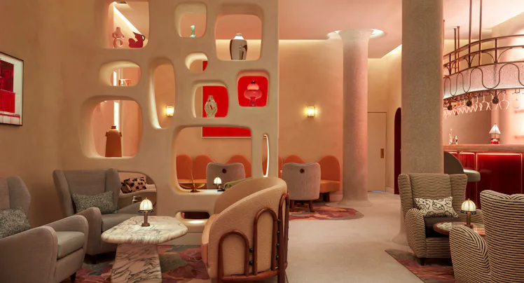 a dimly lit, modernist bar featuring artwork in various shades of red