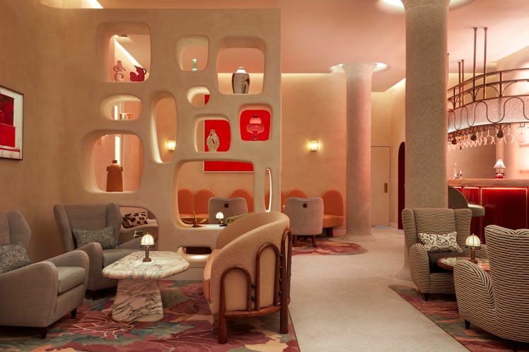 a dimly lit, modernist bar featuring artwork in various shades of red
