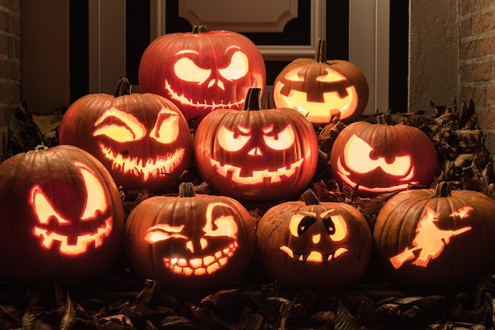 Several jack-o-lanterns stacked together, displayed on a table