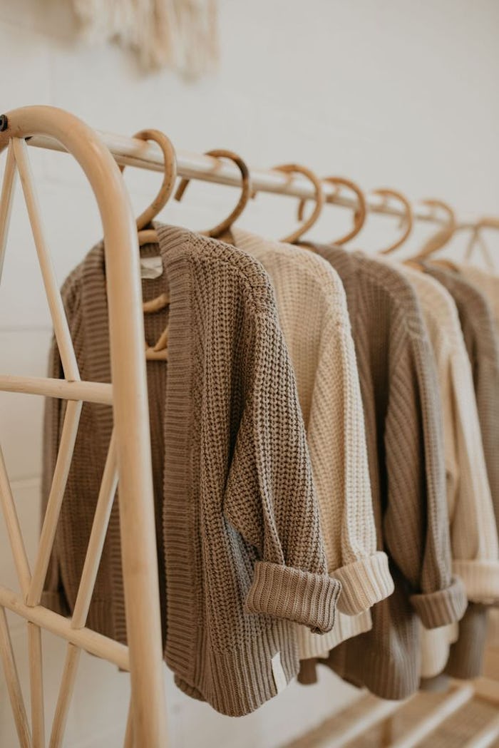 knit cardigans on hangers; hanging on clothing rack