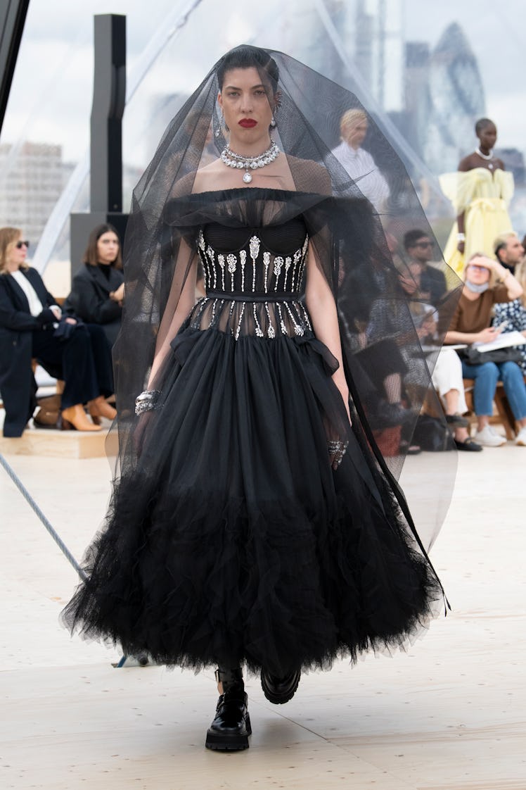 Model walking in a black tulle dress and veil at the Alexander McQueen Spring 2022 show.