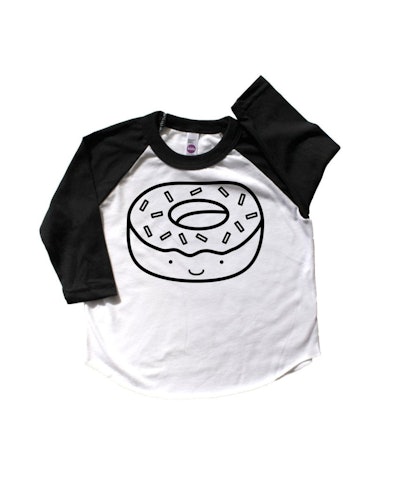 Flat lay of black and white baseball tee with a donut cartoon on the front