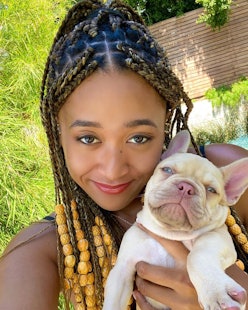 Naomi Osaka in braids and beads with her puppy