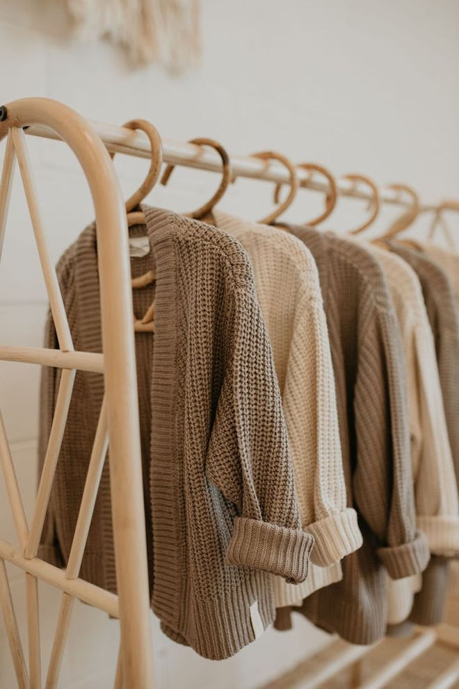 Several knit cardigans hanging on a clothing rack