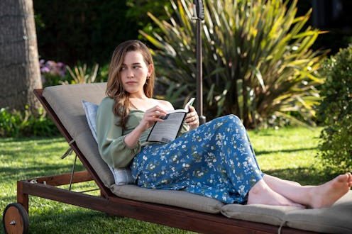 Victoria Pedretti as Love lounging in a scene from YOU Season 3