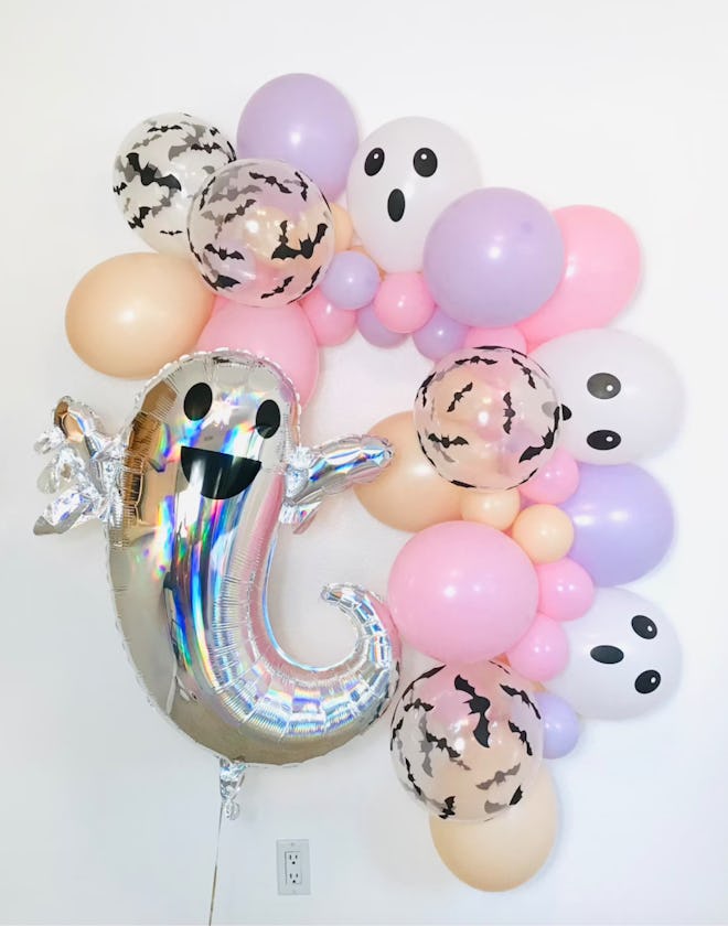 a Halloween balloon garland with pastel balloons and silver ghosts