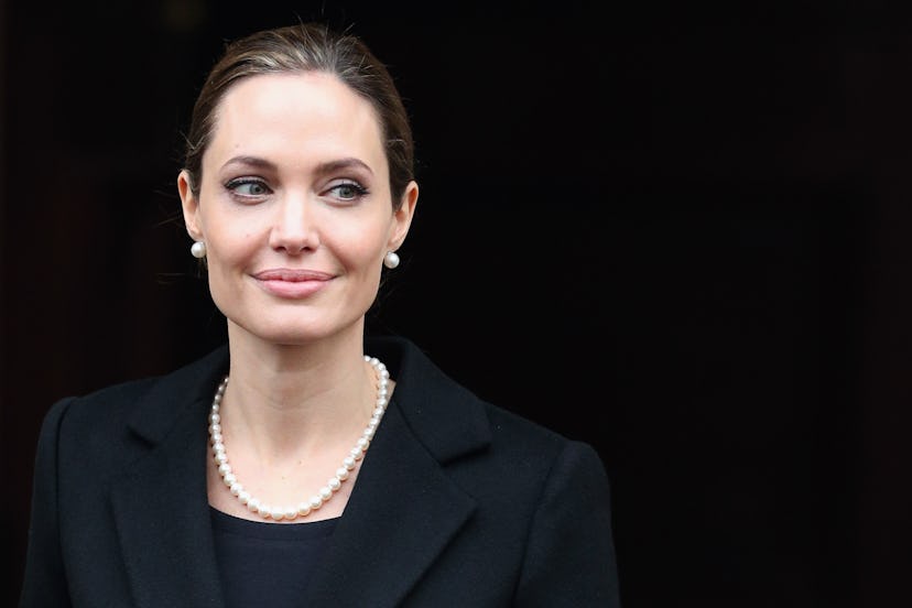 Angelina Jolie on April 11, 2013 in London, England wearing a pearl necklace and pearl stud earrings...