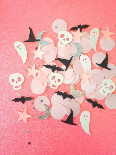 pastel halloween confetti shaped like ghosts, bats, moons, and stars