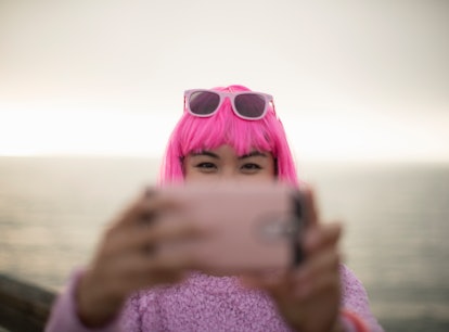 Young woman with a pink wig taking a selfie the week of November 8, 2021, the best week for her zodi...