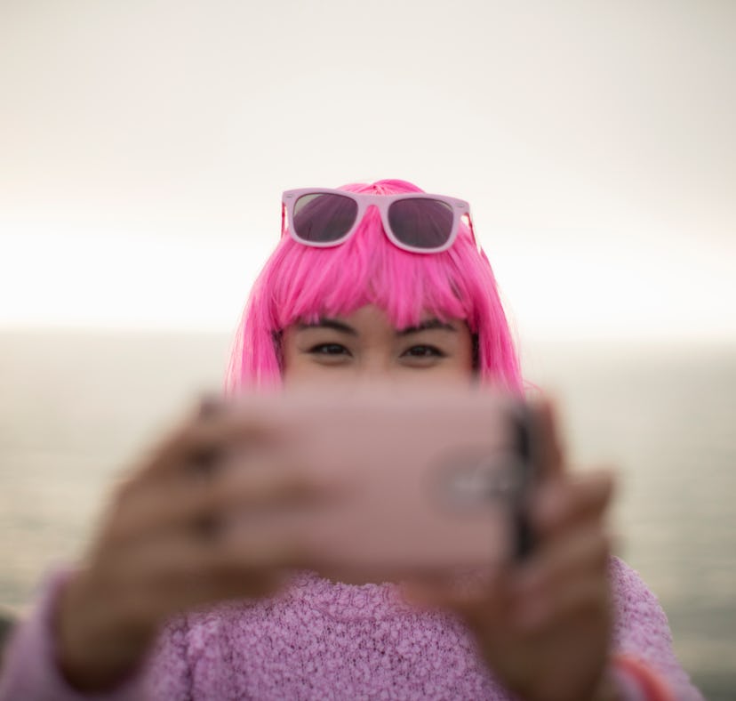 Young woman with a pink wig taking a selfie the week of November 8, 2021, the best week for her zodi...