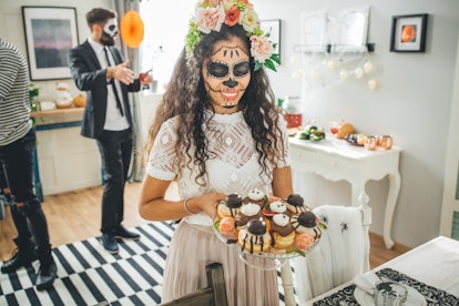 Young woman in costume at a Halloween party after reading her Halloween 2021 horoscope.