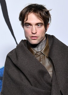 Robert Pattinson in a brown leather shirt and a brown coat