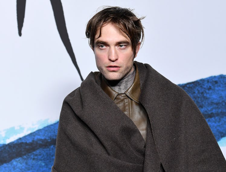 Robert Pattinson in a brown leather shirt and a brown coat