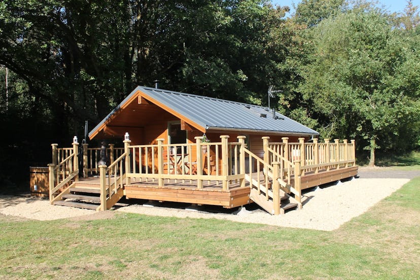 A wooden lodge in Chilworth, Hampshire fully surrounded by a wooden porch