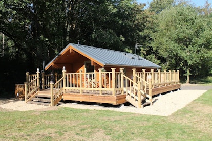 A wooden lodge in Chilworth, Hampshire fully surrounded by a wooden porch